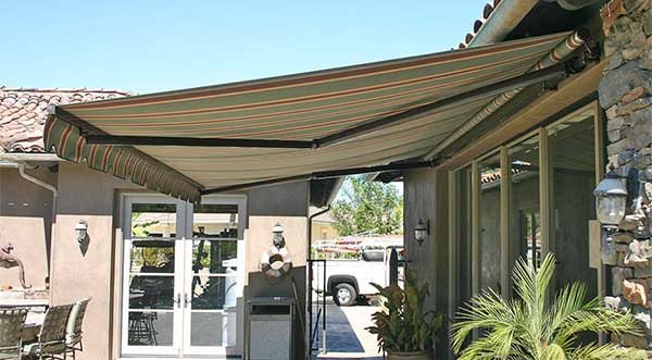 Sun Om Solution retractable fabric awning extended over a patio